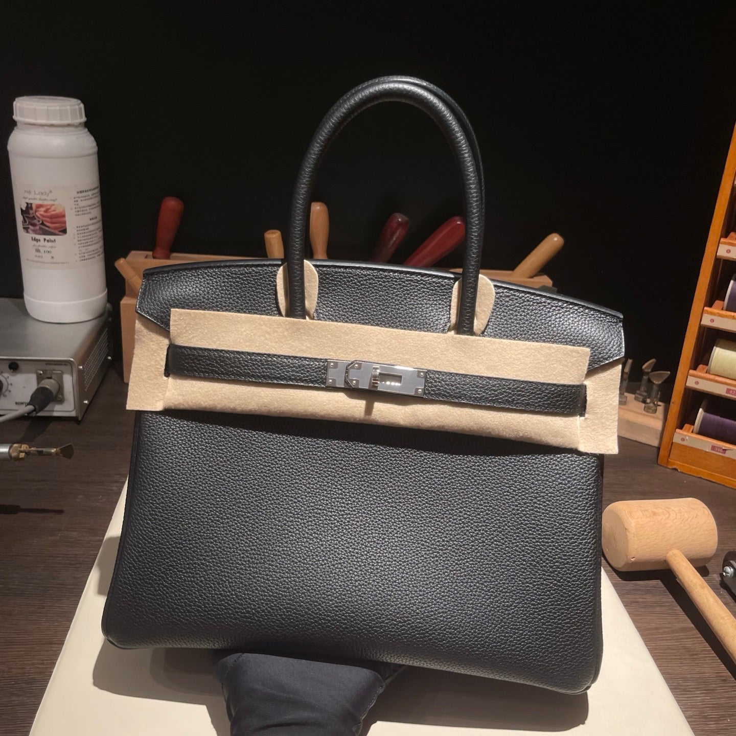 Black Togo leather top handle bag with silver hardware angled view